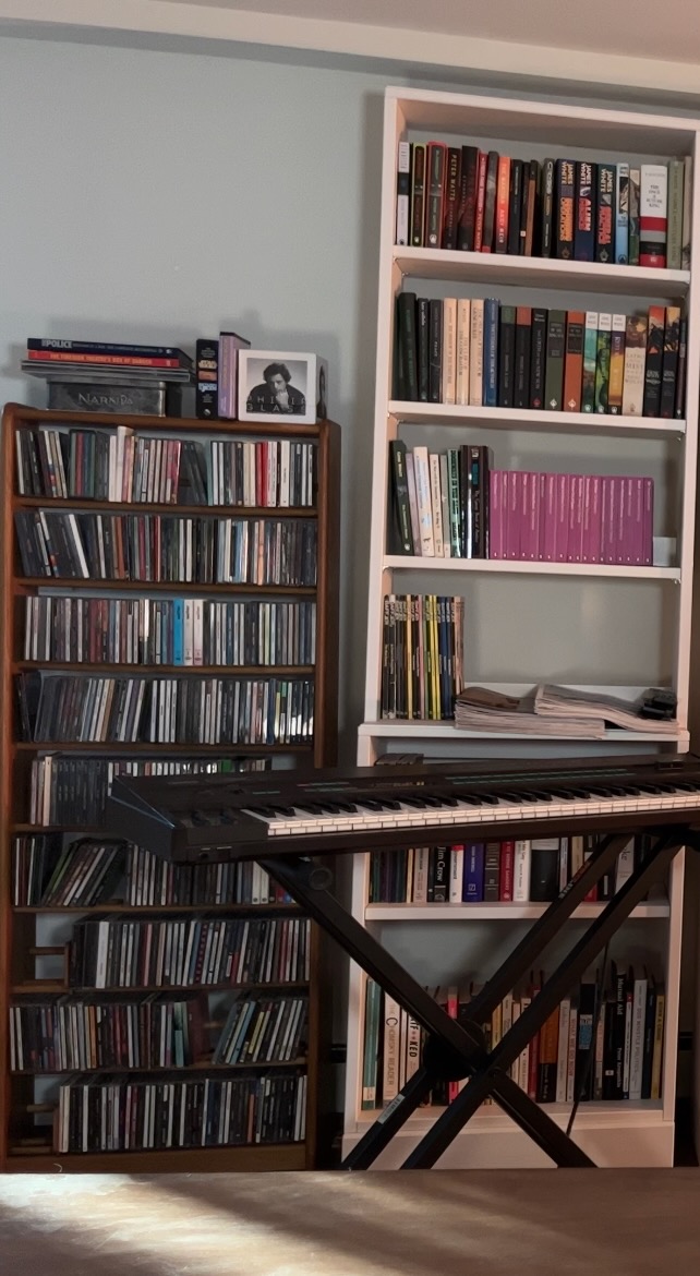 a cropped still frame showing the left side of the basement library, showing beams of sunlight from illuminating the table
